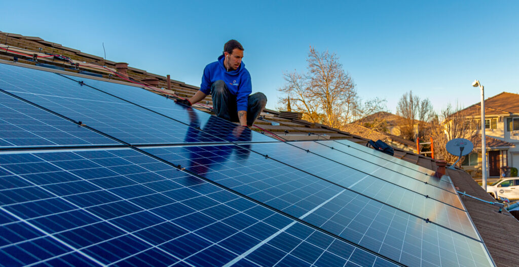 An Epic employee installing solar panels onto a roof.