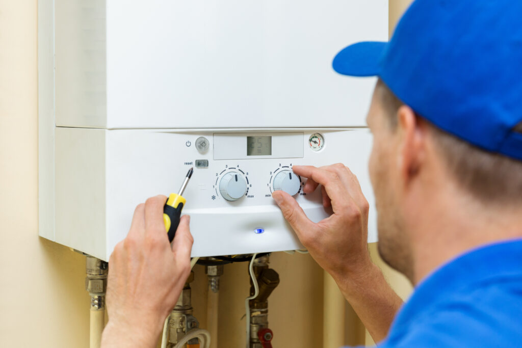 A repairman looking at a water heater.