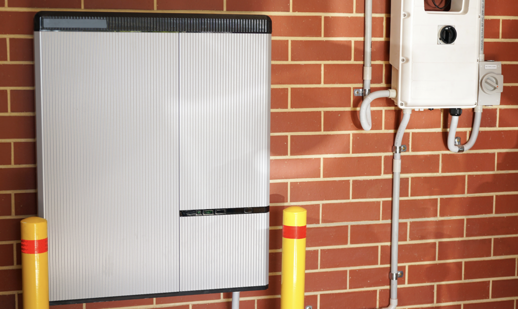 A battery installed on a home's brick wall.