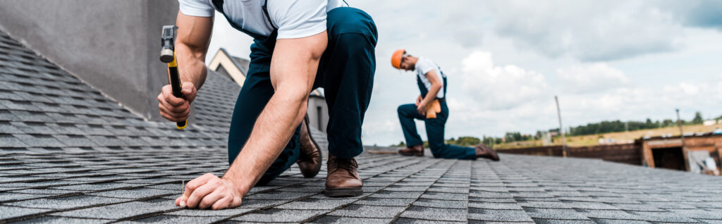 Panoramic shot of handyman repairing roof.