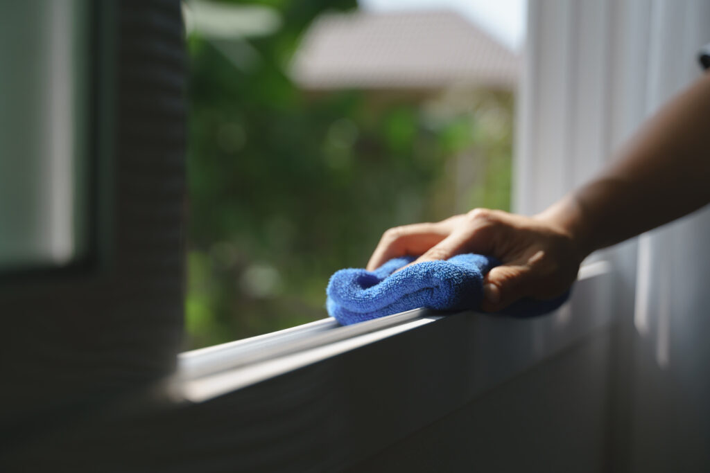 A picture of a person cleaning a window frame.