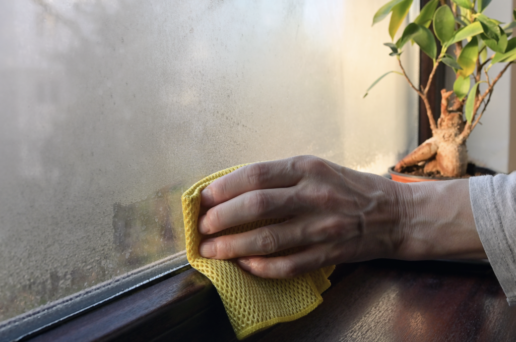 An image of a person wiping down a window.