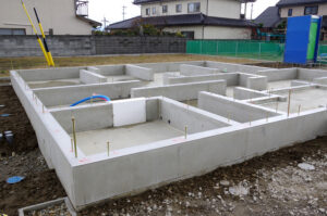 The concrete foundation of a house as it is being laid.