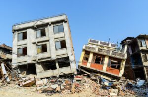 A couple of houses whose foundations have been extremely damaged by an earthquake. The buildings no longer sit flat on the earth.