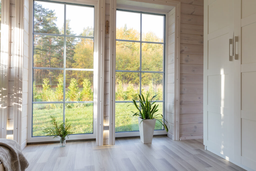 An image of tall windows looking out into a yard.