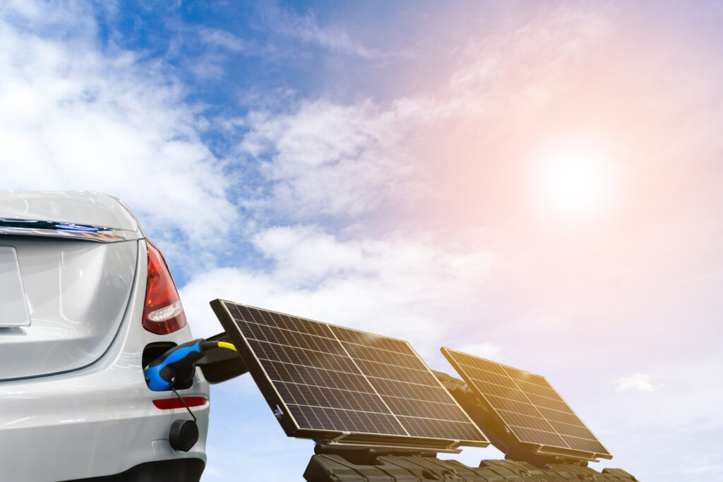 An image of an electric car recharging on solar panels.