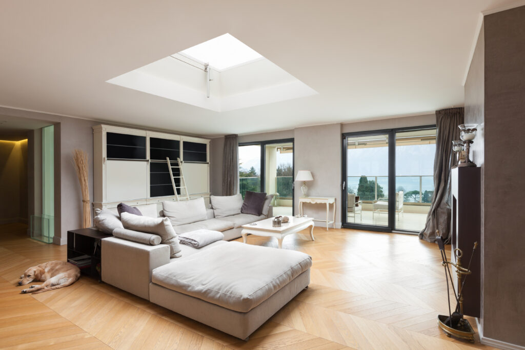 An image of a living room with tall windows looking out over the ocean.