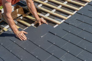 A person installing a slate roof.